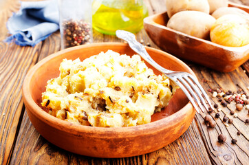 Canvas Print - Simple food mashed potatoes with caramelized onions close-up on a plate on the table.