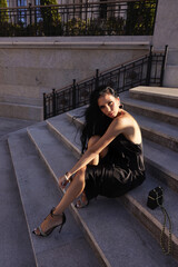 Wall Mural - beautiful woman with dark hair in elegant black dress and accessories posing in beautiful villa