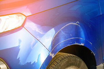 Closeup of crumpled front fender with dents and scratches, damage car's arch and body paint after road collision. Traffic Accident.