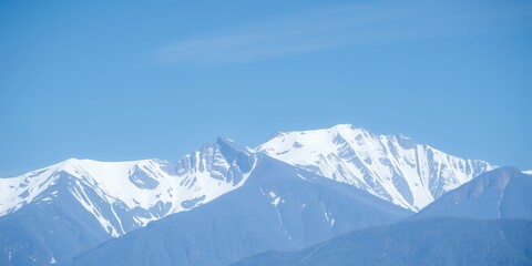 Poster - Snow-capped mountain peaks under a clear blue sky.