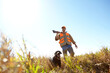 © ReeseBuyout3/peopleimages.com - Man, dog and outdoor for hunting trip, rifle and stalking prey together in nature bush. Mature person, pet animal and hunter support in field to guide in woods, partnership and tracking in sports