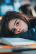 © Alexandra - Teenage student is resting her head on her books, feeling sad and tired after studying