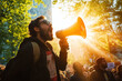 © Alexandra - Young man passionately addresses a crowd, his voice amplified by a megaphone, during a rally for social change