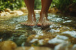© Alexandra - Woman is standing barefoot on stones in cold flowing water, enjoying a kneipp therapy session