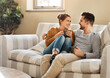 © Chanelle2000/peopleimages.com - Relax, coffee or happy couple laughing on couch with smile or love in house for care, latte and bonding. Apartment, break and people drinking tea beverage on sofa together to chill in lounge in Spain