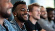 © Michael - Young african american professional smiles while attending a presentation with colleagues
