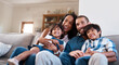 © Chanelle2000/peopleimages.com - Happy, TV and parents with kids in home for bonding, relax and watching movies in living room on sofa. Laugh, family and mom, dad and children on couch streaming cartoons, entertainment and series