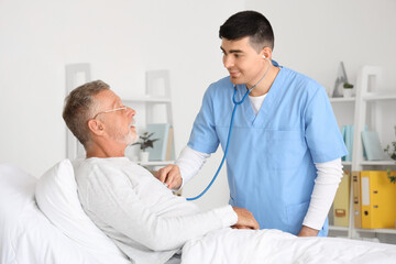 Poster - Male nurse hearing senior man with stethoscope in bedroom