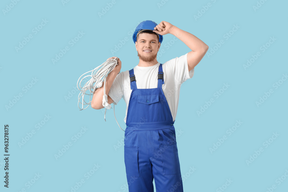 Male contractor with wires on blue background