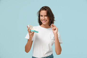 Wall Mural - Pretty young woman with pill and organizer on blue background