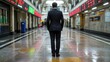 © weerasak - A businessman stands alone in a modern, reflective corridor surrounded by digital displays, symbolizing solitude and contemplation.