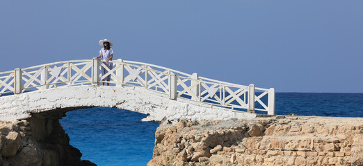 Wall Mural - beautiful brunette woman walking on the bridge by the sea