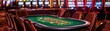 © ManitaSr - Vibrant casino interior featuring a roulette table and slot machines, creating an exciting gambling atmosphere.