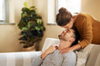 © Chanelle2000/peopleimages.com - Sofa, couple and kiss on forehead for love, affection and bonding together in marriage at home. Happy people, woman and man with romance embrace for admiration, commitment and connection for support