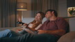 © stockbusters - Relaxed couple switching channels at home sofa evening. Spouses choosing movie