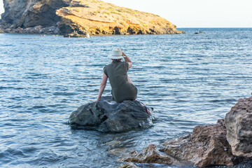 Woman sitting on a rock in the sea