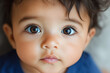 © Jennifer Clason - Aa close-up of a hispanic latino baby with bright eyes, staring directly into the camera, with a pout expression on their face