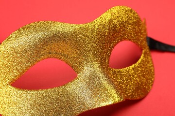 Canvas Print - One golden carnival mask on red background, closeup