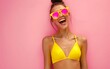 © PGD - A woman wearing a yellow bikini and a pink sunglass