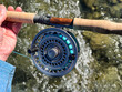 © tab62 - Close up view of male hand holding fly fishing reel and rod while on the river