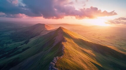 Poster - A mountain range with a sun setting in the background. The sky is cloudy and the sun is setting behind the mountains