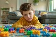 © sergiokat - Portrait of a child with autism playing with colorful building blocks, deeply focused and happy