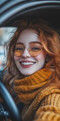 Wall Mural - Smiling young woman with curly red hair in cozy sweater inside car