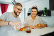 © Dusan - Two friends male and female are eating croissant for breakfast