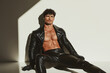 © Augustino - Famous Gay, Queer Art concept. Portrait of a biker bodybuilder wearing black leather clothing, posing on white background. Text space. Studio shot