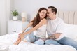 © New Africa - Happy couple spending time together on bed at home