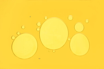 Poster - Sample of cosmetic oil on yellow background, macro view