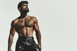 © Augustino - Famous Gay, Queer Art concept. Portrait of a biker bodybuilder wearing black leather clothing, looking up, posing on white background. Text space. Studio shot