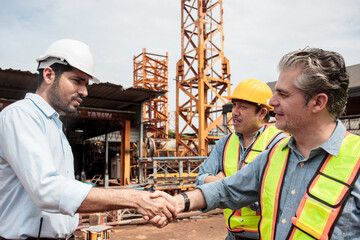 Team of workers at construction site with heavy machines.