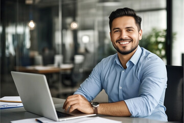 Smiling businessman working on laptop in office