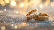 © MakoPoko - A pair of gold wedding rings placed on a soft, blurred background with shimmering bokeh lights. The rings symbolize eternal love and commitment.
