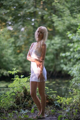 Portrait of a young beautiful blonde girl in a summer forest.