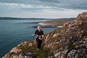 A girl standing on the shore of the Barents Sea in Teriberka