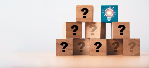 Poster - Glowing lightbulb on the top of wooden cube of question for problem solving solution and creative thinking idea concept.
