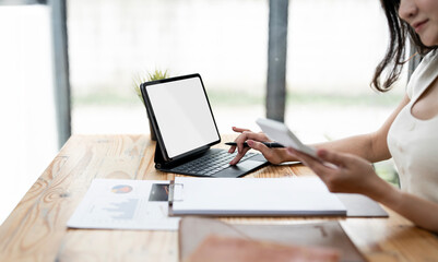 Fototapete - Woman typing on a laptop with a blank screen at a desk in a well-lit home office