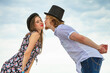 © Voyagerix - Couple flirting kissing on date against sky background