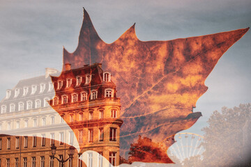 Autumn yellowed leaf in woman's hand superimposed on image of old building on French street. Traveling to France in autumn. Fall season trip to Europe