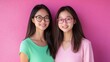 © starush - Two asian women wearing glasses posing for a picture against pink wall, AI