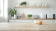 © hanisah - Natural wooden table Blurred background with family dining room and minimalist kitchen interior. Wooden table, kitchenware and appliances on furniture and shelves, white wall