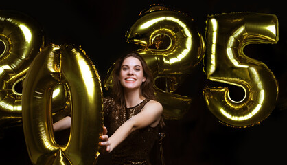 Wall Mural - Happy gorgeous girl in stylish sexy party dress holding gold 2025 balloons, having fun at New Year's Eve Party.