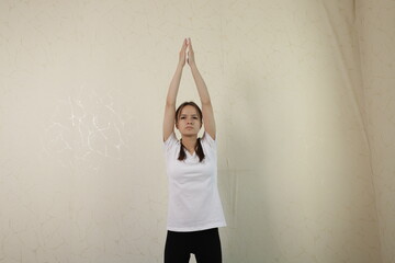 Wall Mural - Teenage girl doing gymnastics at home, fit teenager learning new gymnastic positions, energetic exercise routine for a healthy lifestyle.