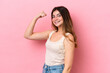 © luismolinero - Young caucasian woman isolated on pink background doing strong gesture