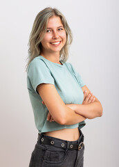 Cute and joyful young woman with arms crossed looking at the camera.