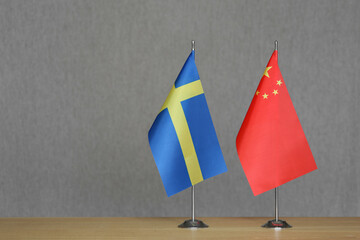 Table flags of China and Sweden on grey blurred background