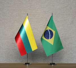 Table flags of Brazil and Lithuania on a gray blurred background