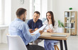 © Studio Romantic - Young caucasian couple sitting at the desk discussing contract and having consultation with man realtor or financial advisor in office. Insurance agent consulting man and woman in office.